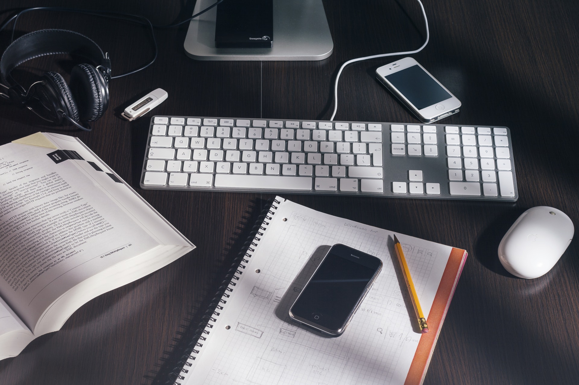 Schreibtisch mit Notizblock, Smartphone und Tastatur